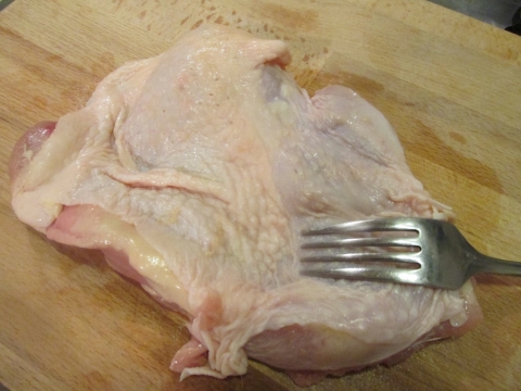 鶏肉をフォークで刺す１
