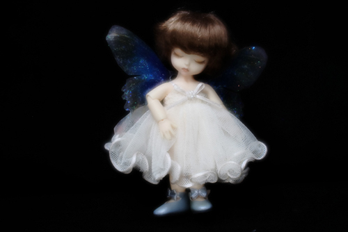 DOLL FACTORY・Baby Ariの小さな眠り目の子、Emma（エマ）。妖精の羽をまとって、夜の暗がりの中で光り輝いている。