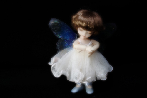 DOLL FACTORY・Baby Ariの小さな眠り目の子、Emma（エマ）。妖精の羽をまとって、夜の暗がりの中で光り輝いている。